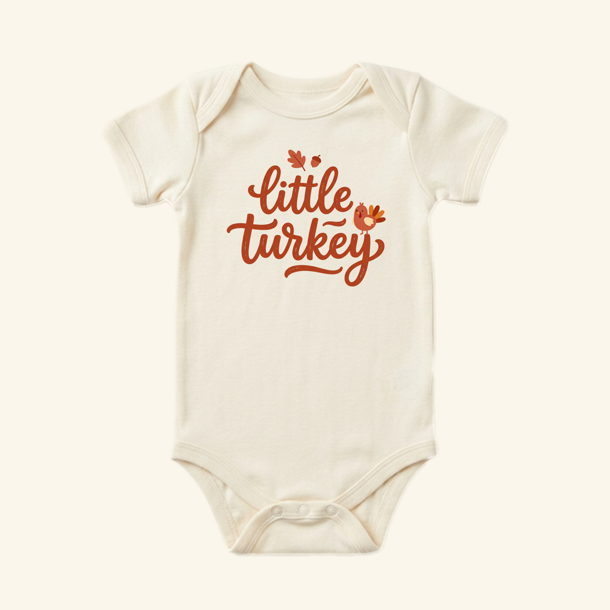 Cream-colored Little Turkey Baby Onesie – Hand-Lettered Thanksgiving Bodysuit featuring little turkey in brown cursive with leaf, acorn, and turkey illustrations, perfect for a baby’s first Thanksgiving.