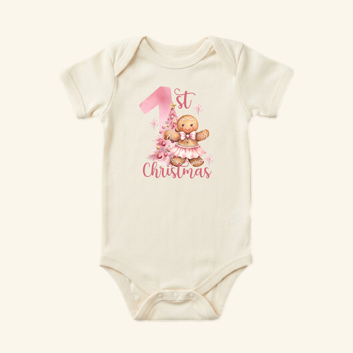Cream-colored Baby Girl First Christmas Onesie – Gingerbread Holiday Bodysuit featuring a gingerbread person wearing a pink tutu and the text 1st Christmas.
