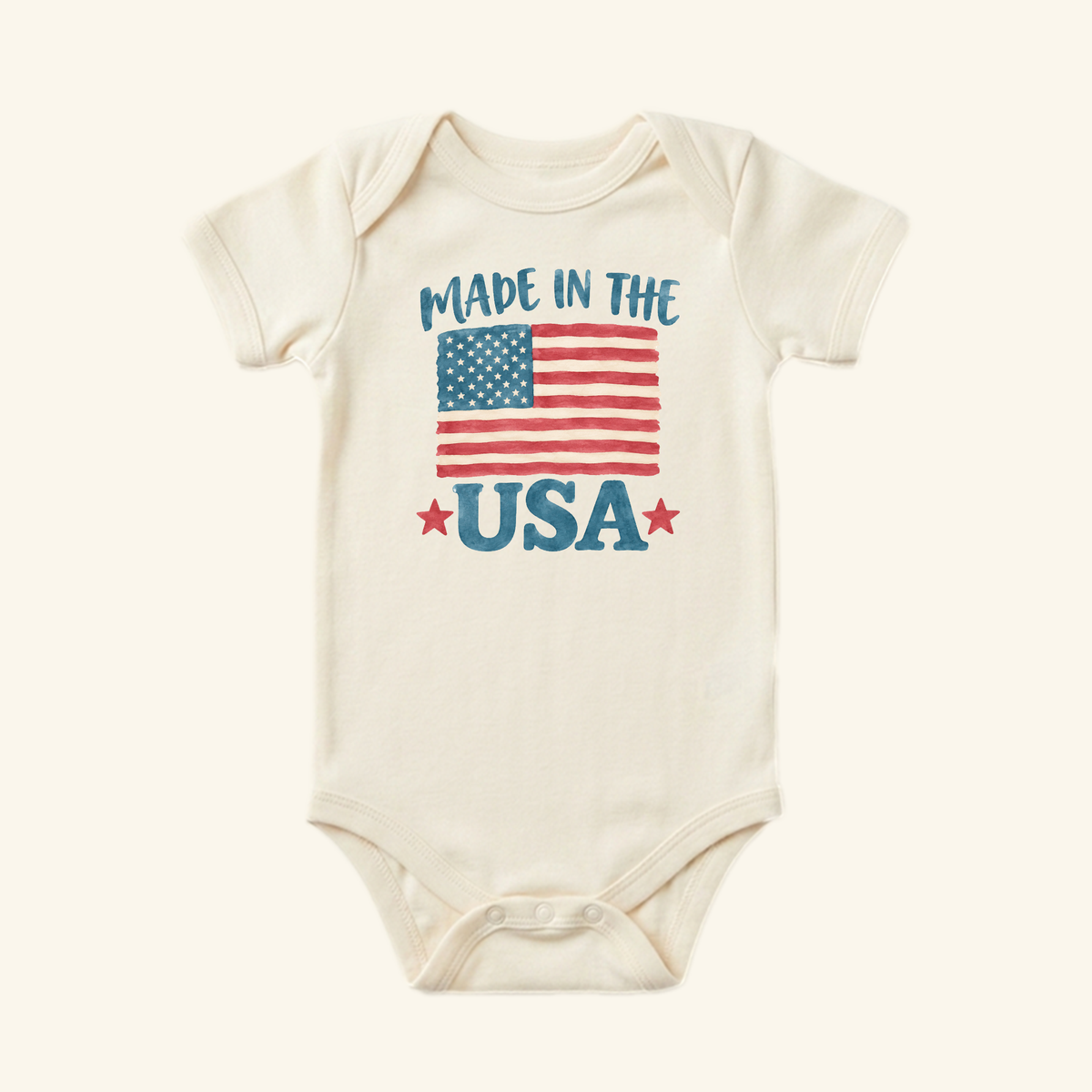 Cream-colored Made in the USA Baby Onesie – Patriotic American Flag Bodysuit featuring an American flag graphic and the text MADE IN THE USA with two red stars.