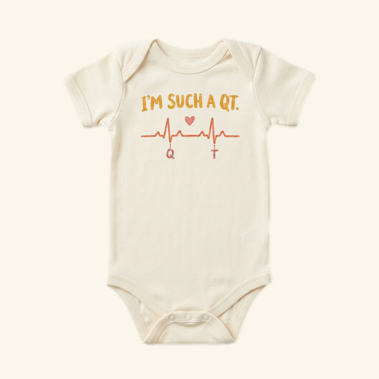 Cream-colored I’m Such a QT Baby Onesie – Funny EKG Heartbeat Nurse Bodysuit printed with I’m such a QT and a graphic of a heartbeat line featuring a small heart, playing on the QT interval.