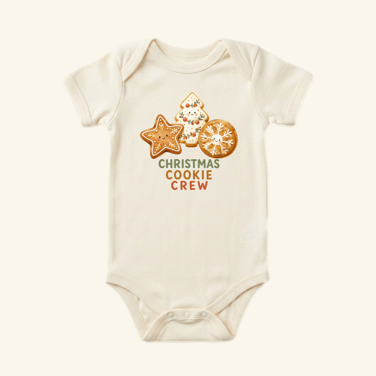 Cream-colored Toodleroos Christmas Cookie Crew Baby Onesie featuring illustrations of three decorated Christmas cookies and the text Christmas Cookie Crew.