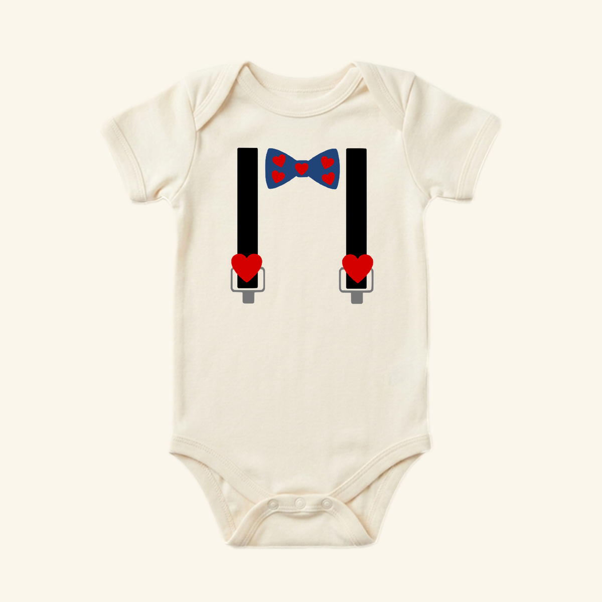 Toodleroos Valentine’s Day Baby Onesie – Heart Bow Tie & Suspenders Bodysuit in cream, featuring a navy blue bow tie with red hearts connected to black suspenders with red heart accents.