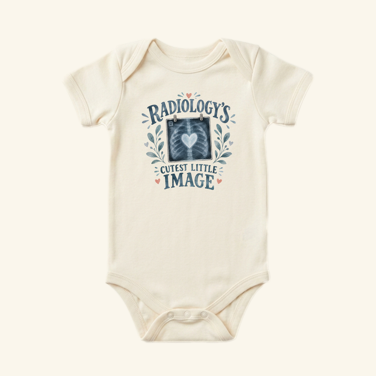 Off-white Radiology’s Cutest Little Image Baby Onesie – Rad Tech Bodysuit featuring an X-ray illustration of a ribcage with a central heart, surrounded by leaf accents and the text Radiology’s Cutest Little Image.