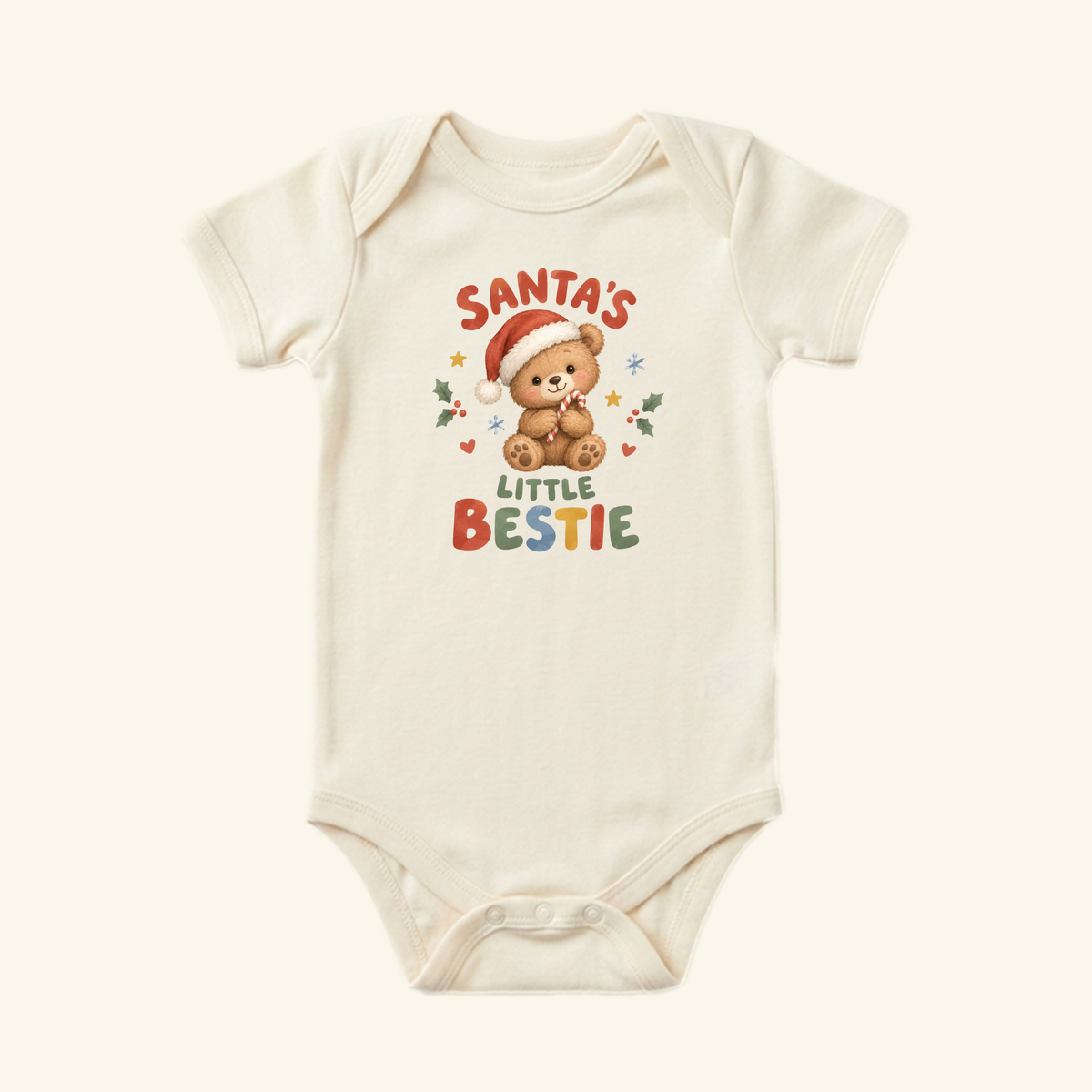 Toodleroos Santa’s Little Bestie Baby Onesie – Teddy Bear Christmas Bodysuit in cream, featuring a teddy bear in a Santa hat holding a candy cane, surrounded by holiday icons and the text Santa’s Little Bestie.