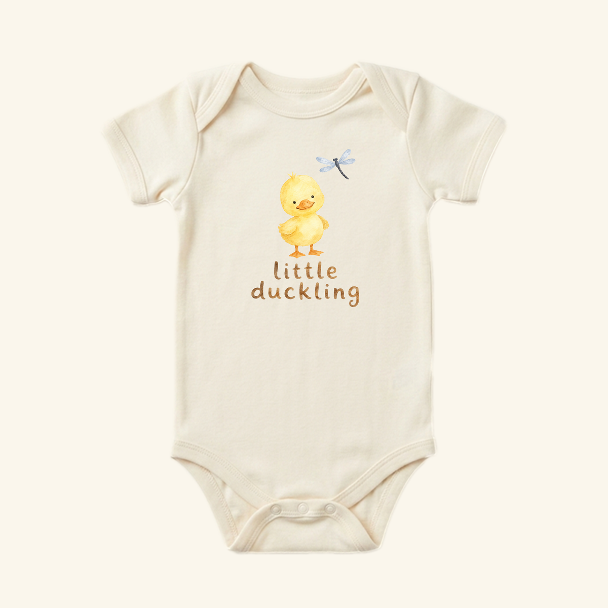 Toodleroos Little Duckling Baby Onesie in off-white featuring a watercolor illustration of a yellow duckling, a dragonfly, and the text little duckling.