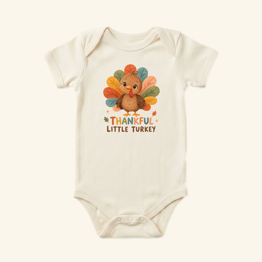Cream-colored Thankful Little Turkey Baby Onesie – Thanksgiving Bodysuit for babies featuring a cartoon turkey with colorful feathers and the text THANKFUL LITTLE TURKEY.
