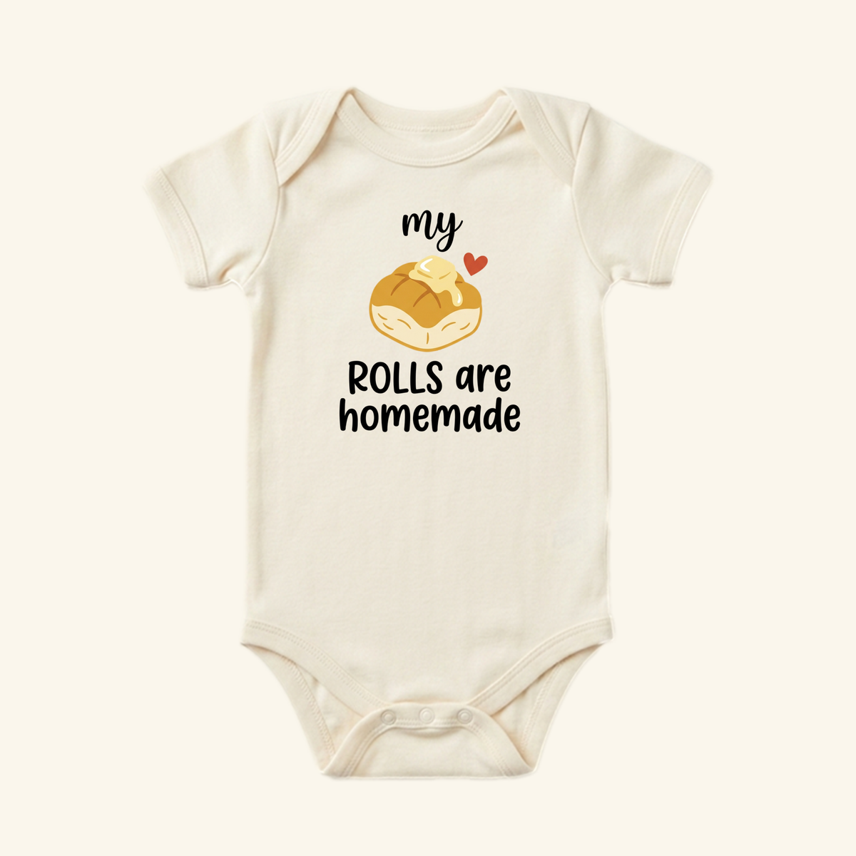 Cream-colored My Rolls Are Homemade Baby Thanksgiving Onesie - Fall Bodysuit featuring an illustration of a dinner roll with a pat of butter and the text my ROLLS are homemade.
