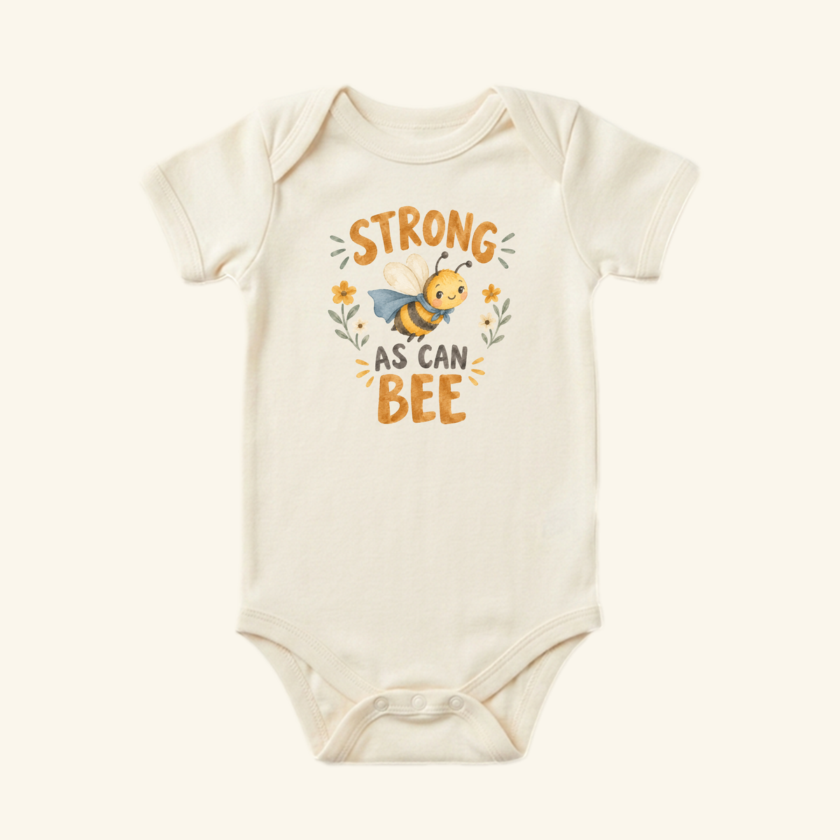 Off-white Strong As Can Bee Baby Onesie – Superhero Bee Bodysuit featuring a graphic of a smiling superhero bee wearing a cape.