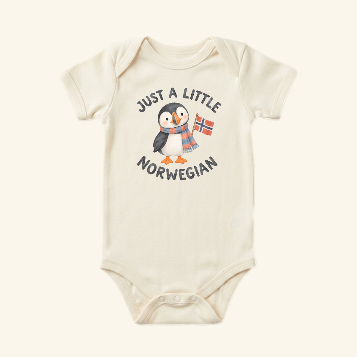 Cream-colored Just a Little Norwegian Baby Onesie – Cute Puffin Norway Flag Bodysuit featuring a puffin wearing a scarf and holding a Norwegian flag, with the text Just a little Norwegian arched around it.