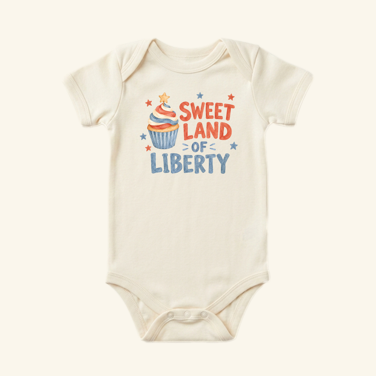 Off-white Toodleroos Sweet Land of Liberty Baby Onesie – Patriotic Cupcake Bodysuit featuring a red, white, and blue cupcake graphic with the text Sweet Land of Liberty.