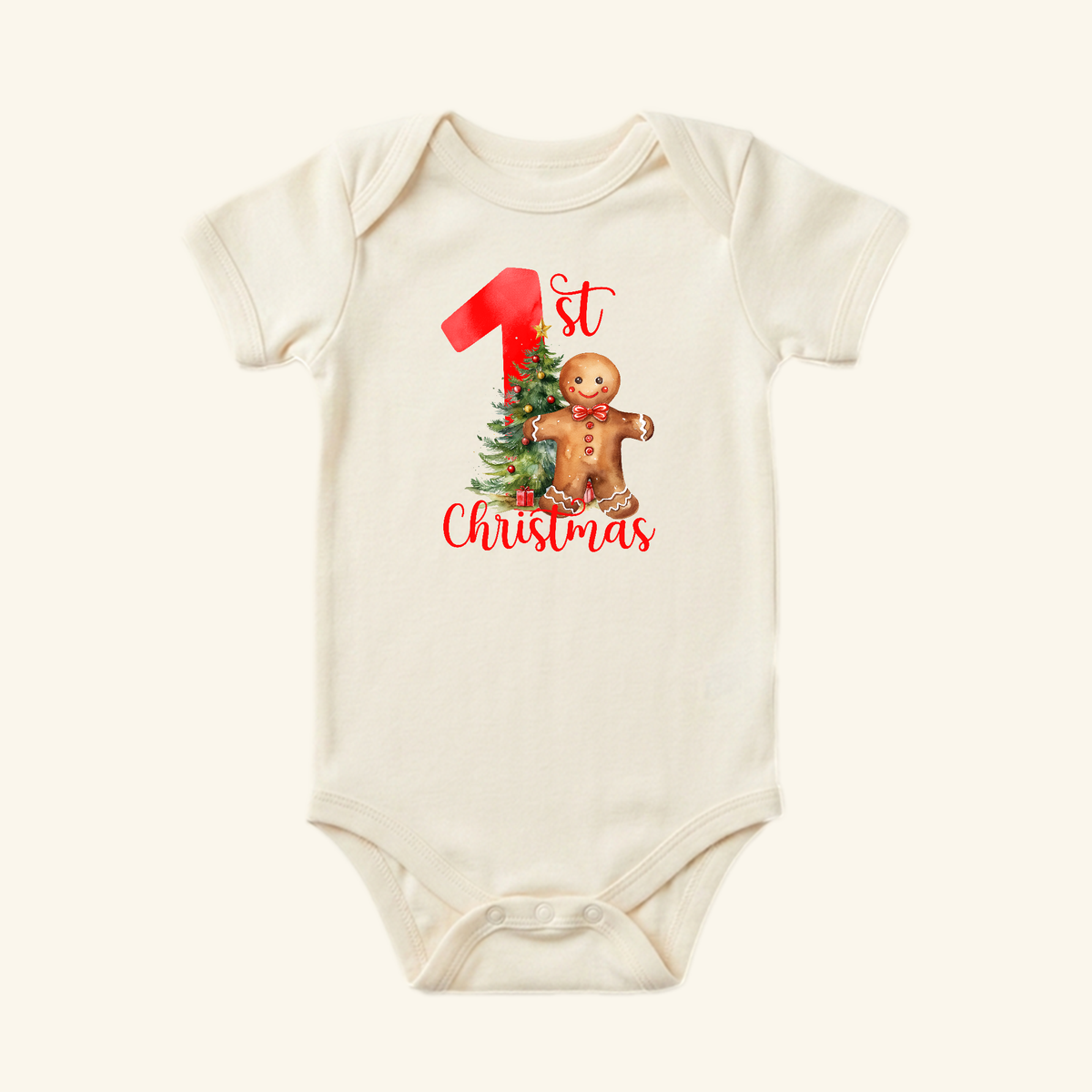 Cream-colored Baby’s First Christmas Onesie – Gingerbread Holiday Bodysuit featuring a gingerbread man, a decorated Christmas tree, and the text 1st Christmas.