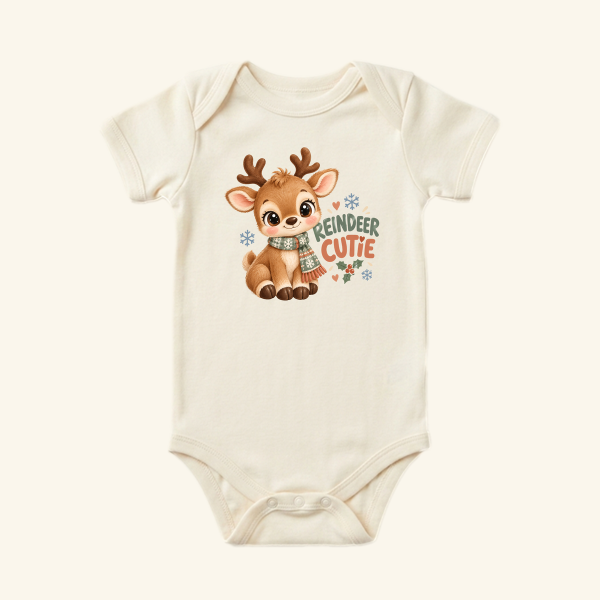 Cream-colored Reindeer Cutie Baby Onesie featuring a cartoon reindeer in a scarf, with the text REINDEER CUTIE and holiday accents.