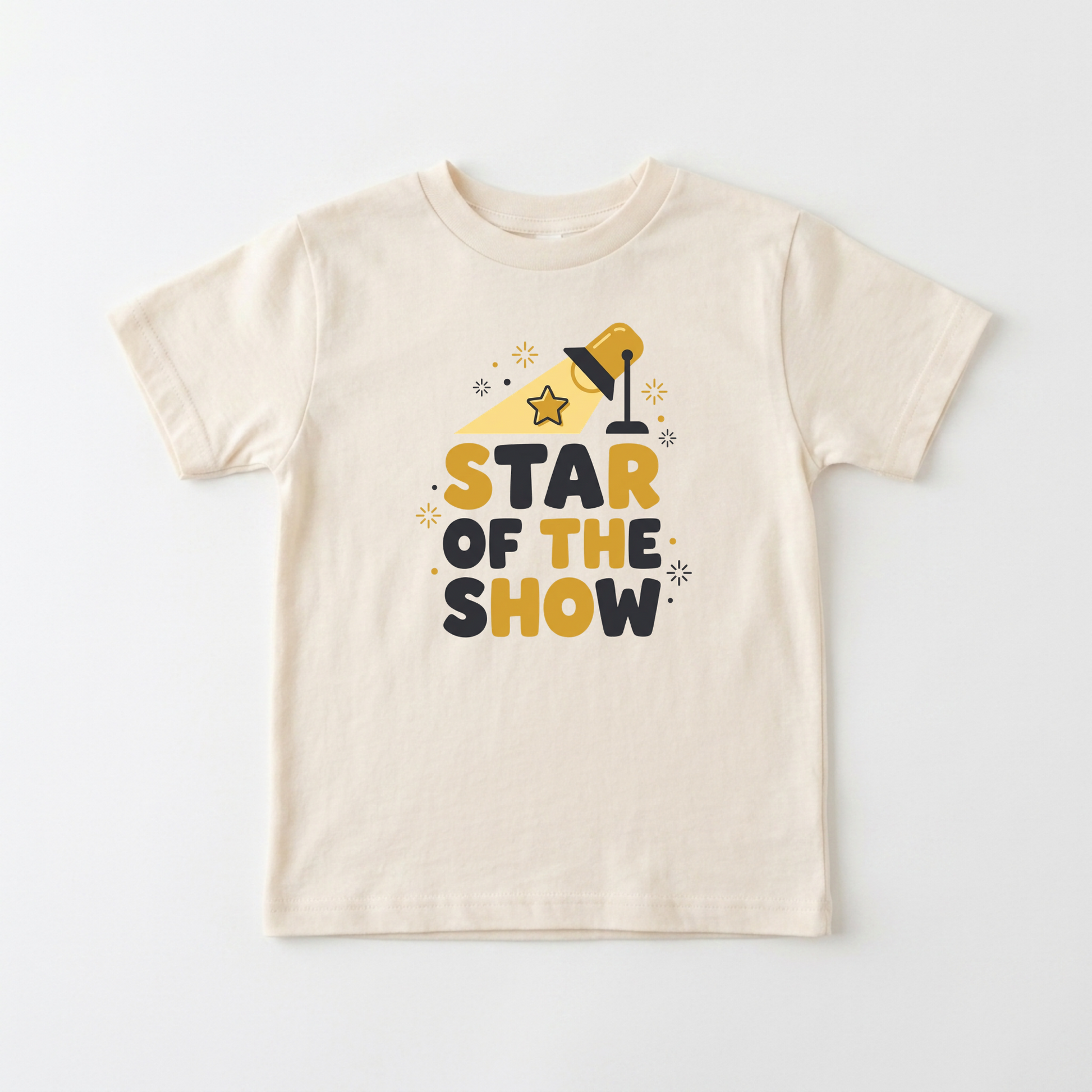 A cream-colored short-sleeve kids' t-shirt with a graphic print that reads 'STAR OF THE SHOW' in yellow and dark navy blue letters, accompanied by a yellow spotlight and star illustrations, displayed on a clean white background.