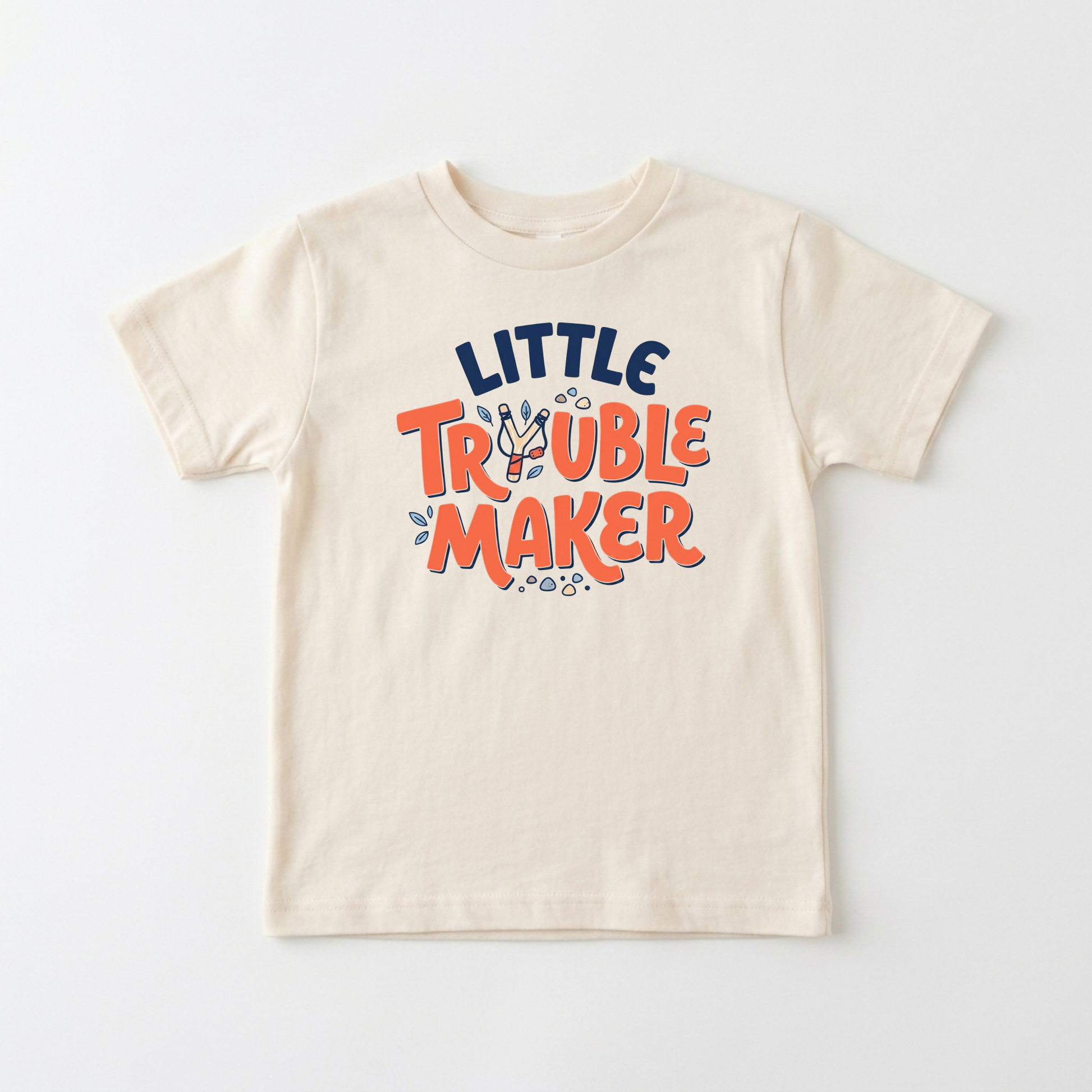 A cream-colored short-sleeve t-shirt with a colorful graphic on the chest that reads 'LITTLE TRouble MAKer' in navy blue and orange lettering, displayed flat against a light gray background.