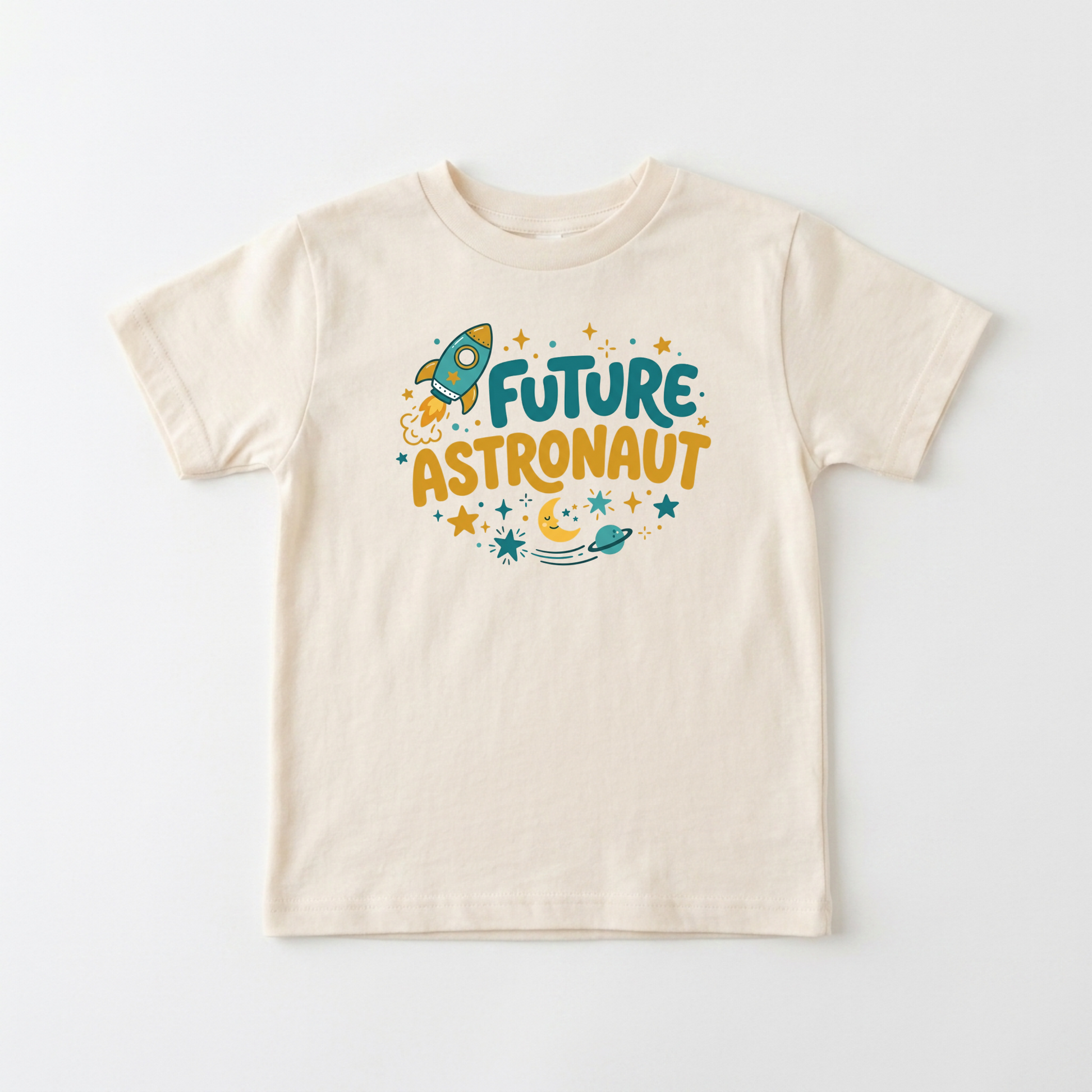 A cream-colored short-sleeve t-shirt with a colorful graphic on the chest that reads 'FUTURE ASTRONAUT' in teal and mustard yellow, surrounded by a rocket ship, stars, and a crescent moon, displayed on a clean white background.