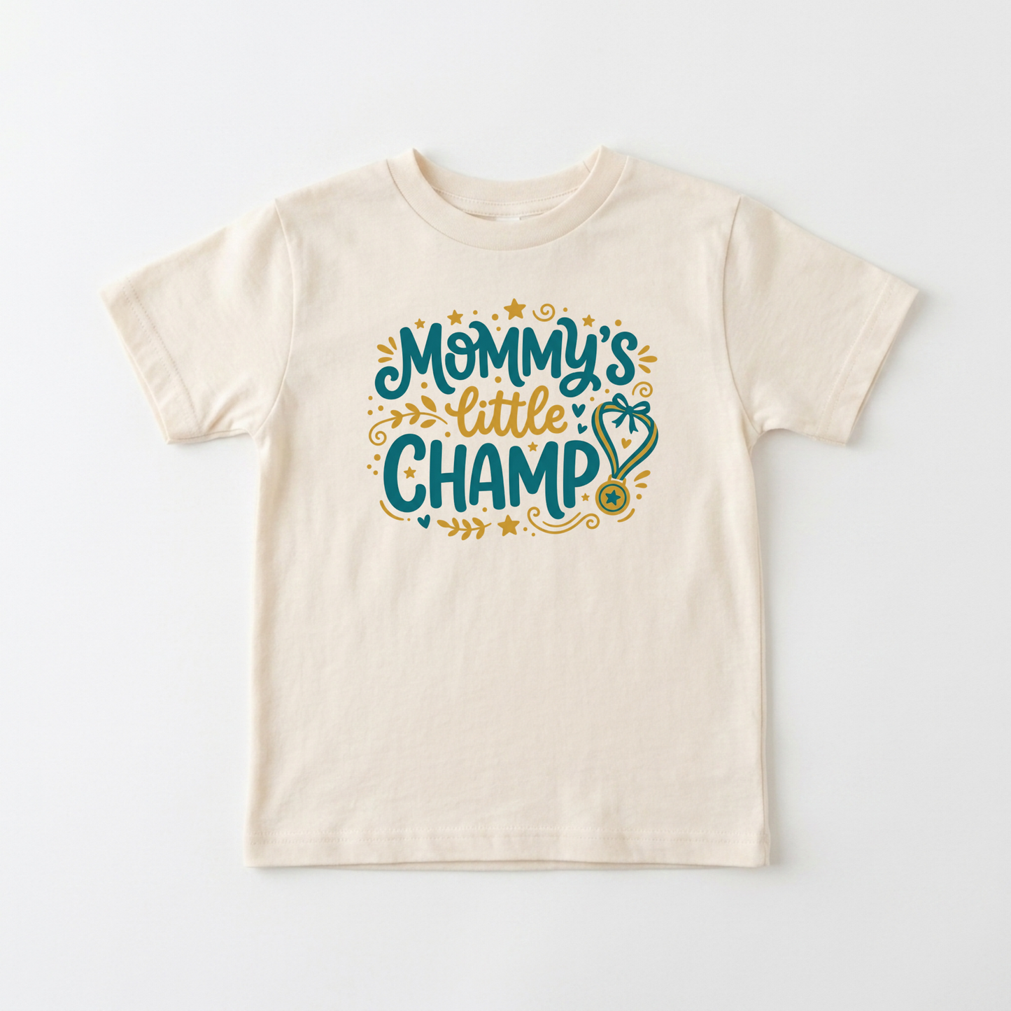 An off-white short-sleeve kids' t-shirt with a colorful graphic on the chest that reads 'Mommy's little CHAMP' in teal and gold lettering with decorative stars and a stethoscope.