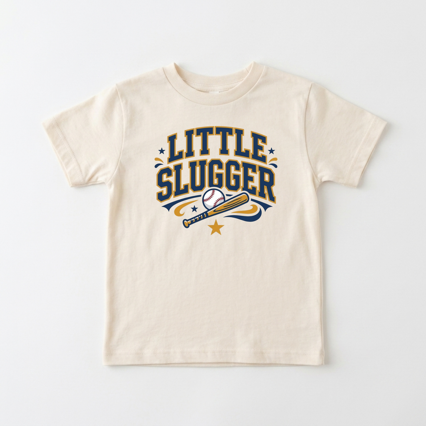 A cream-colored short-sleeve t-shirt with a 'LITTLE SLUGGER' baseball graphic in navy blue and gold, displayed flat against a light gray background.