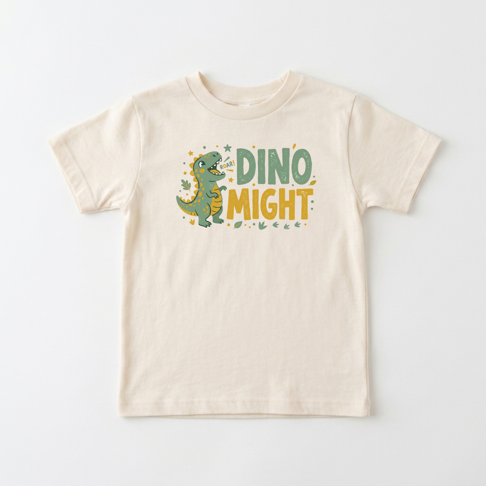 A cream-colored short-sleeve kids' t-shirt featuring a cartoon green dinosaur and the text 'DINO MIGHT' in green and yellow on the front, displayed against a clean white background.