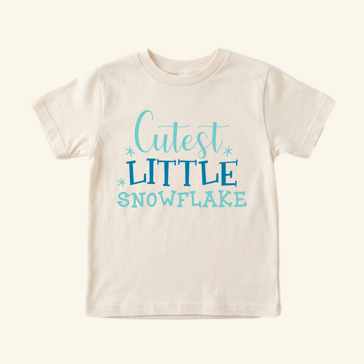 Winter Toddler Shirt – Cutest Little Snowflake Tee in cream, featuring Cutest Little Snowflake in blue lettering with small snowflake accents.