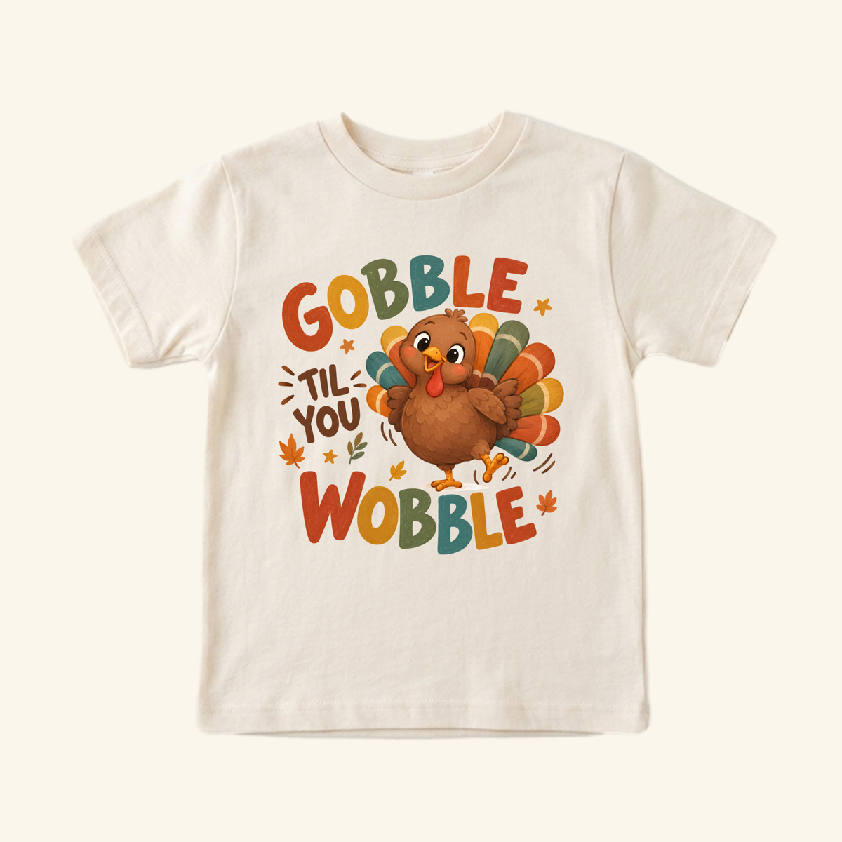 Cream-colored Gobble Til You Wobble Toddler Thanksgiving Shirt – Funny Turkey Tee featuring a cartoon turkey and the text Gobble Til You Wobble.