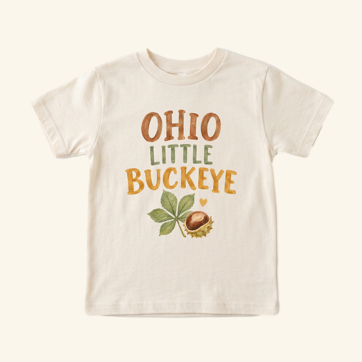 Cream-colored Ohio Toddler Shirt – Little Buckeye Watercolor Nut & Leaf Tee featuring a watercolor illustration of a buckeye nut and leaf with the text OHIO LITTLE BUCKEYE.