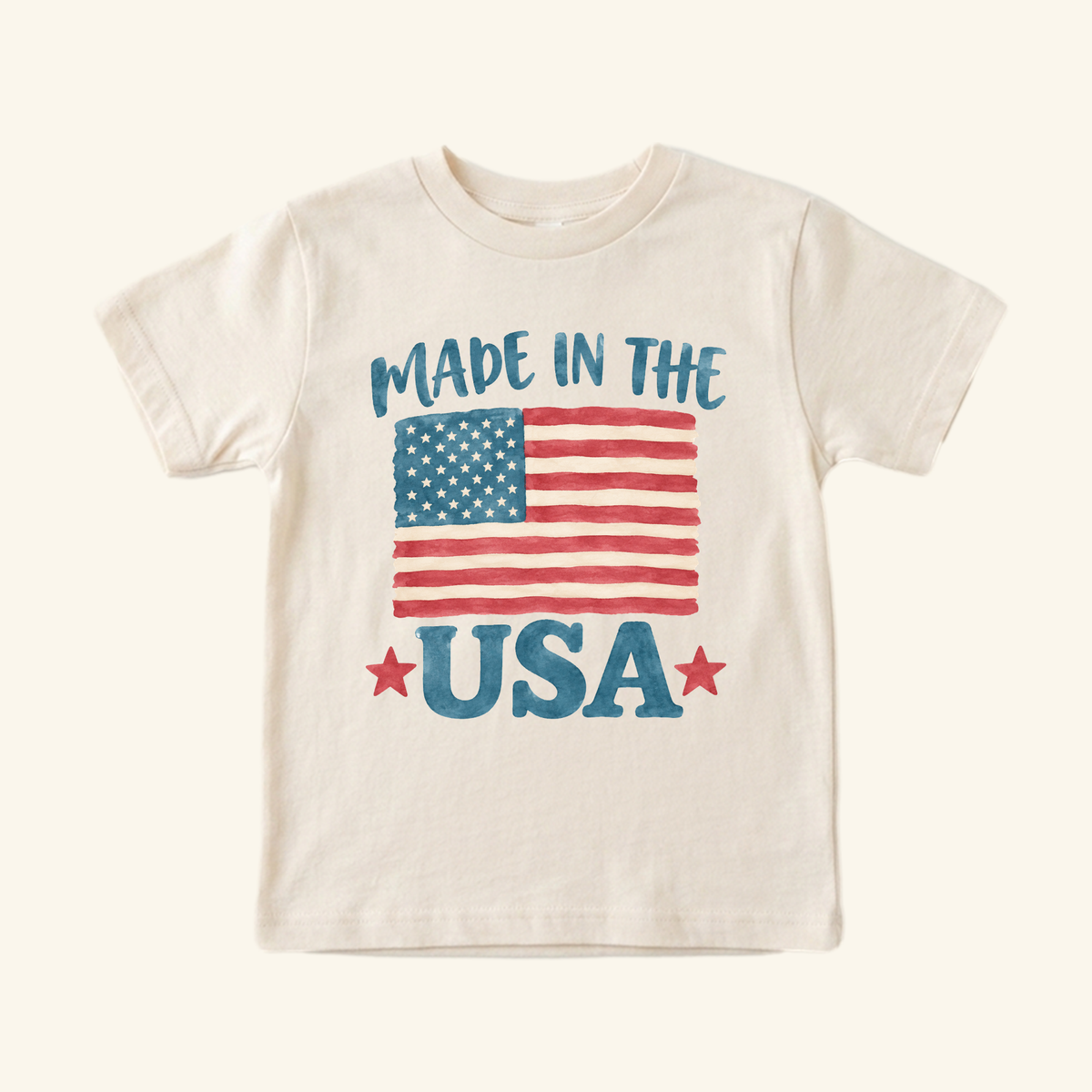 Off-white Made in the USA Toddler Shirt – Patriotic American Flag Tee featuring a watercolor-style American flag graphic, the text MADE IN THE USA, and two red stars.