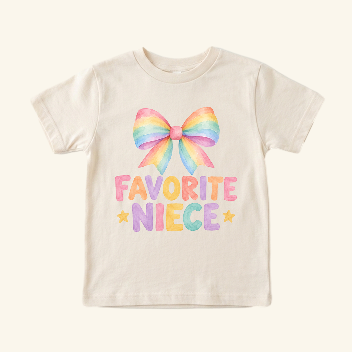 A light-colored Favorite Niece Toddler Shirt – Cute Rainbow Bow Tee featuring a watercolor rainbow bow above the text FAVORITE NIECE flanked by two small stars, perfect as a coquette style shirt.
