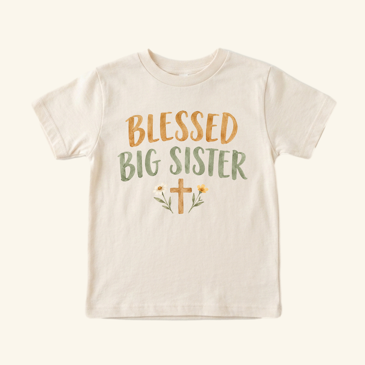 Toodleroos Blessed Big Sister Toddler Shirt: a short-sleeve tee featuring yellow and green text above a small floral cross illustration.