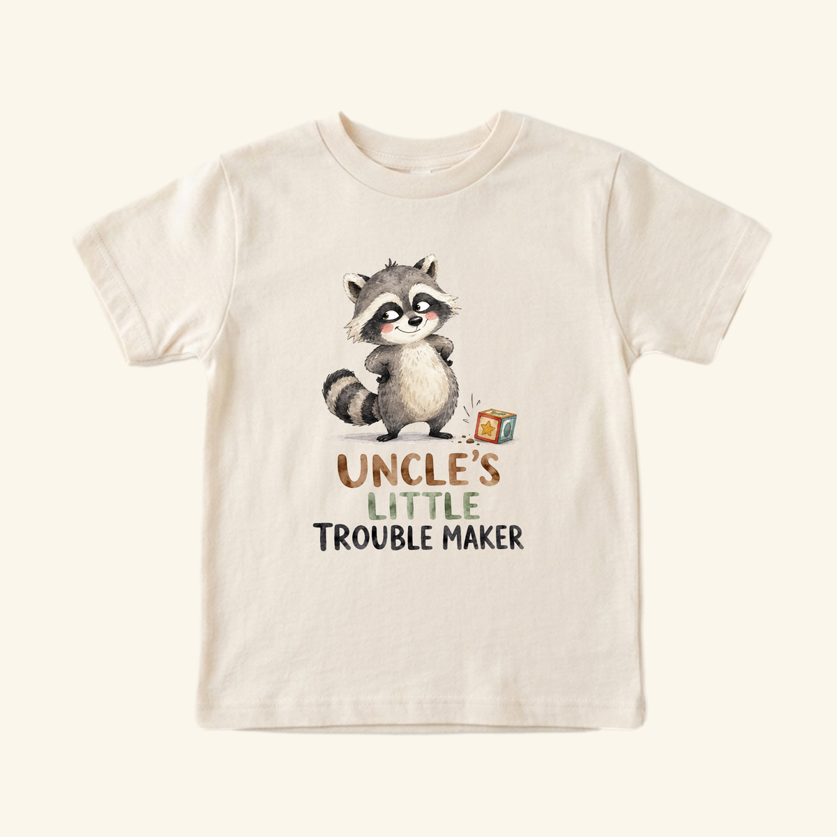 A beige toddler Funny Uncle Toddler Shirt – Uncle’s Little Troublemaker Tee featuring a watercolor illustration of a raccoon and the text Uncle’s Little Troublemaker.