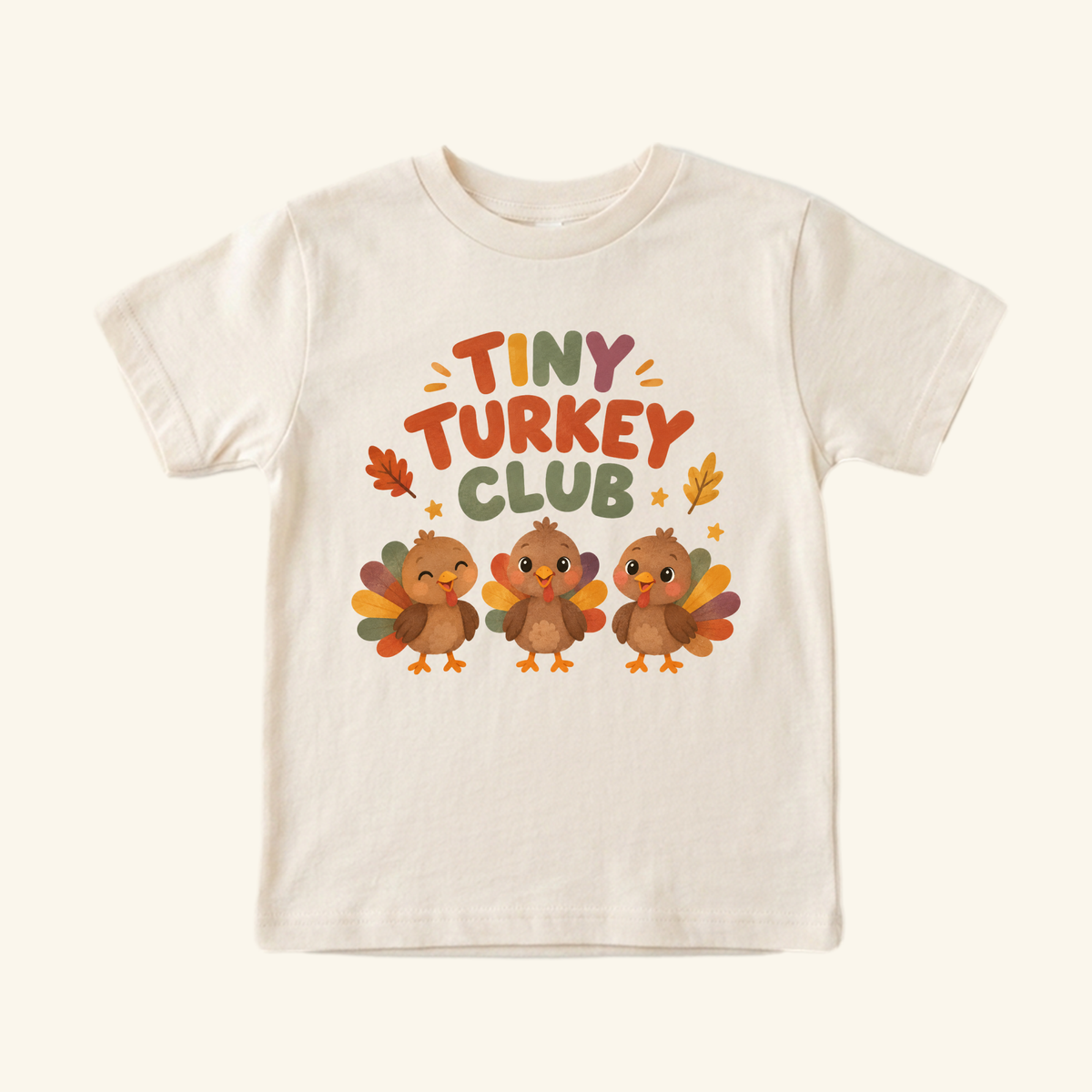 Cream short-sleeve Tiny Turkey Club Toddler Thanksgiving Shirt featuring three cartoon turkeys and playful, colorful lettering.
