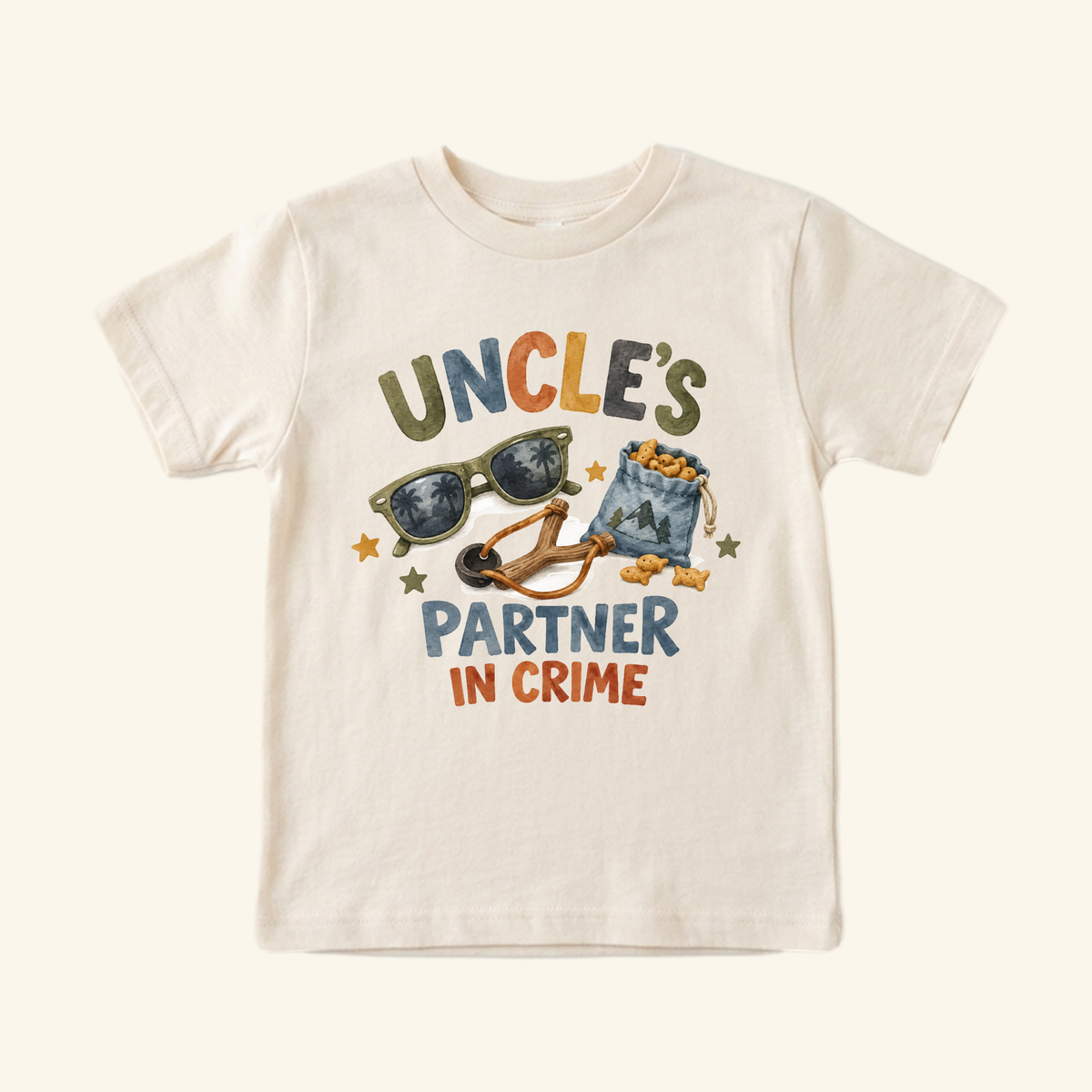 Funny Uncle Toddler Shirt – Uncle’s Partner in Crime short-sleeve toddler tee featuring the text Uncle’s Partner in Crime with illustrations of sunglasses, a slingshot, and a snack bag.