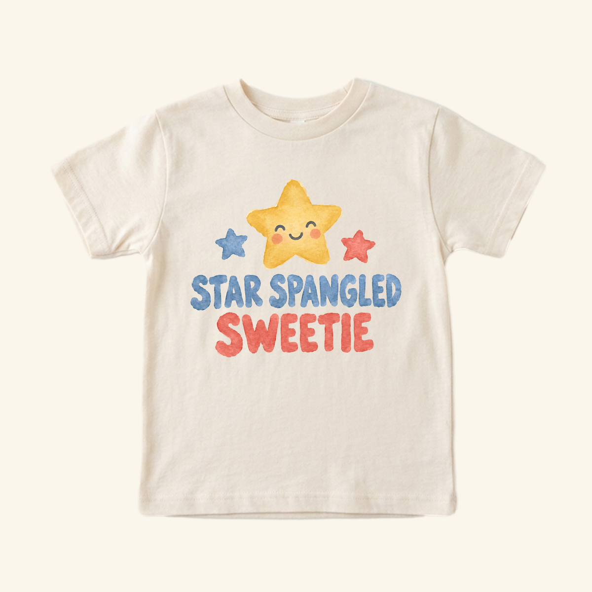 Cream-colored Star Spangled Sweetie Toddler Shirt featuring a watercolor graphic of a smiling yellow star flanked by blue and red stars, with the text STAR SPANGLED SWEETIE printed below.