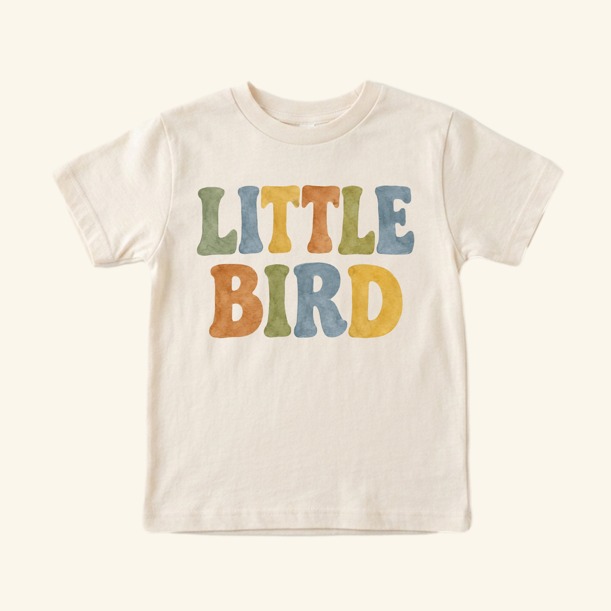 Cream Little Bird Toddler Shirt – Retro Watercolor Lettering Tee with LITTLE BIRD printed across the chest in colorful, retro watercolor-style letters.