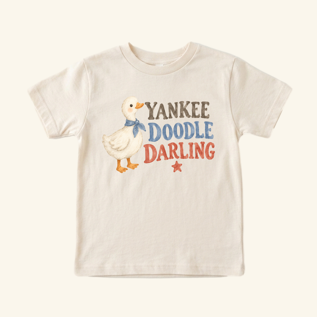 Toodleroos Yankee Doodle Darling Toddler Shirt in cream, featuring a drawing of a duckling in a blue neckerchief next to the text YANKEE DOODLE DARLING and a small red star.