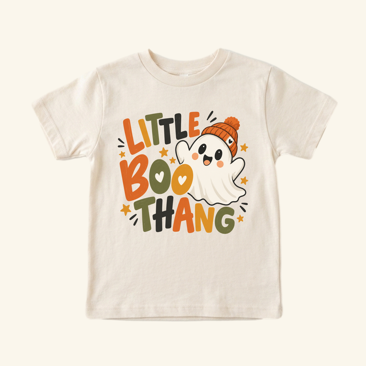 Toodleroos Little Boo Thang Ghost Toddler Halloween Shirt featuring a cream-colored toddler tee with a smiling ghost in an orange knit hat, the text LITTLE BOO THANG, and small stars.