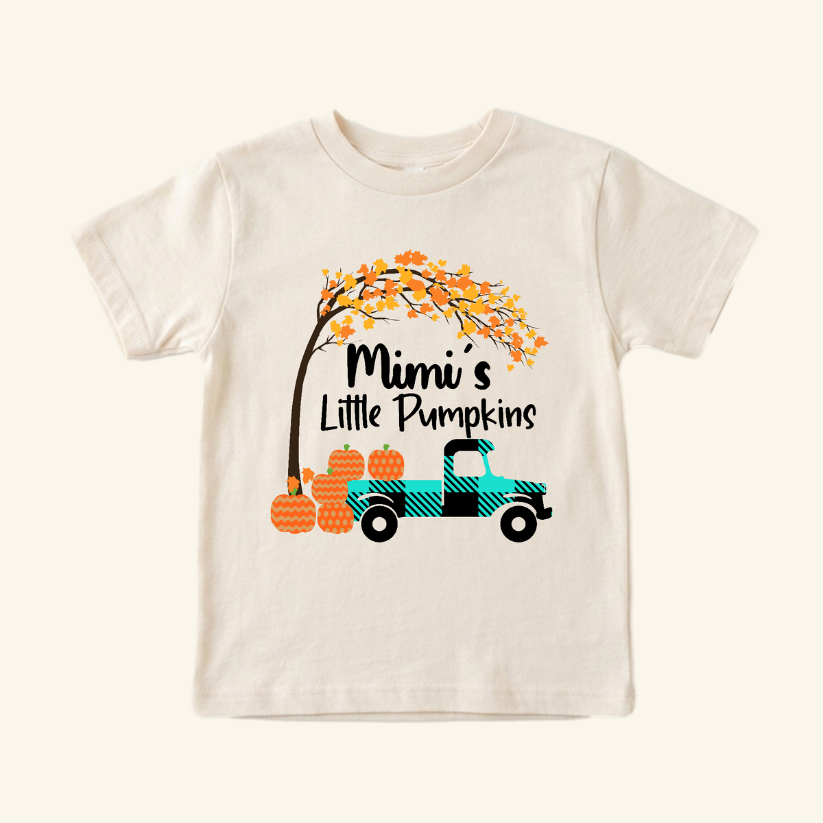 Cream-colored Mimi’s Little Pumpkins Toddler Shirt featuring a plaid truck carrying pumpkins under a fall tree.
