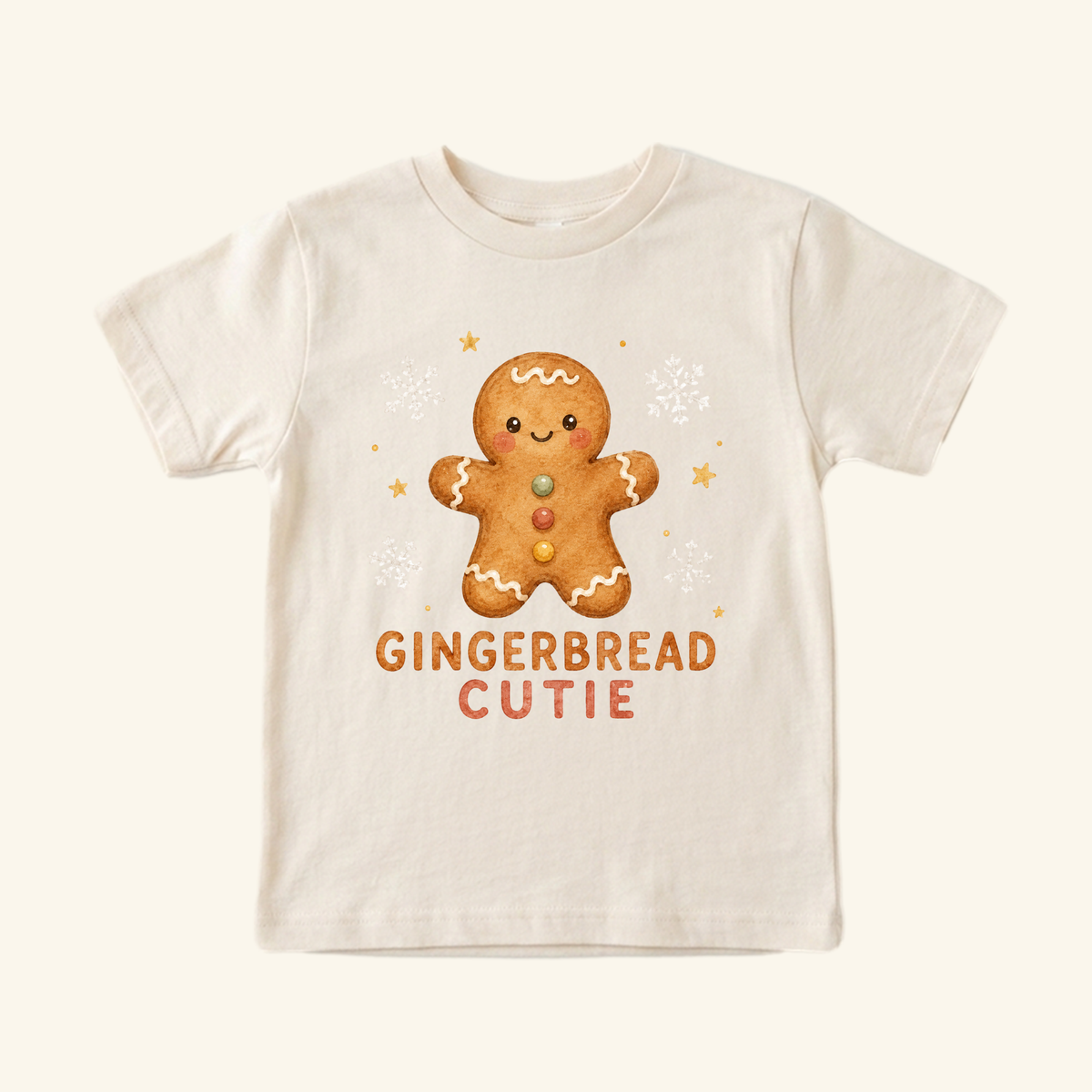 A cream-colored, short-sleeved Gingerbread Cutie Toddler Shirt – Cute Christmas Gingerbread Man Tee featuring a watercolor gingerbread man graphic with the text GINGERBREAD CUTIE below it.