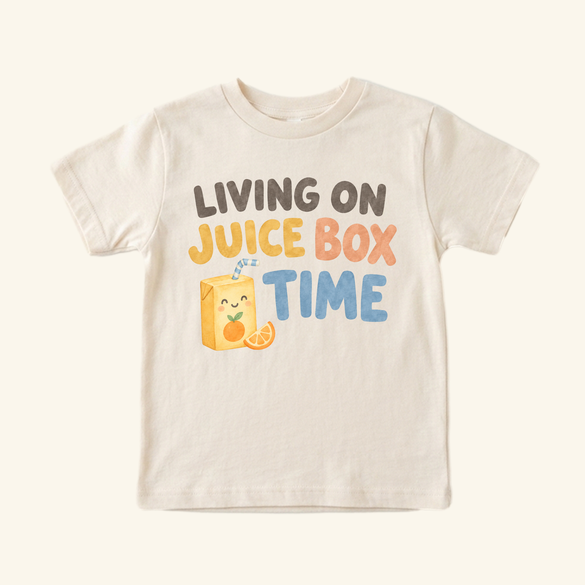A cream Living on Juice Box Time Toddler Shirt – Funny Juice Box Tee featuring an illustration of a smiling juice box with an orange slice and the text Living on juice box time.