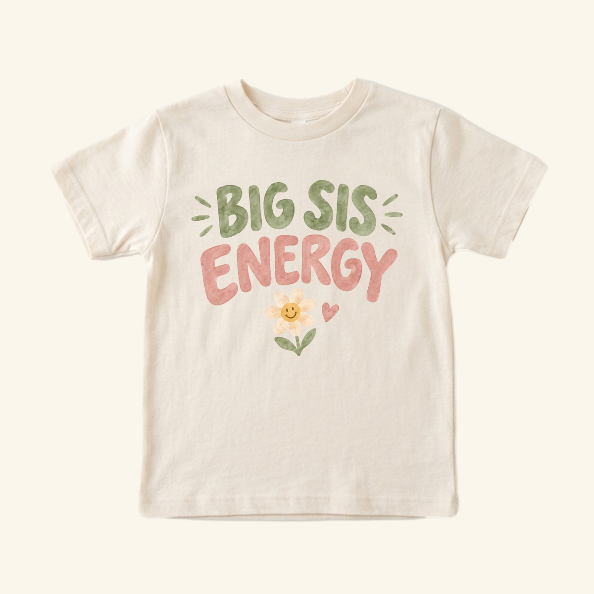 Cream-colored Toodleroos Big Sis Energy Toddler Shirt – Smiley Daisy Sibling Tee with green and pink lettering above a small daisy with a smiley face and a heart.