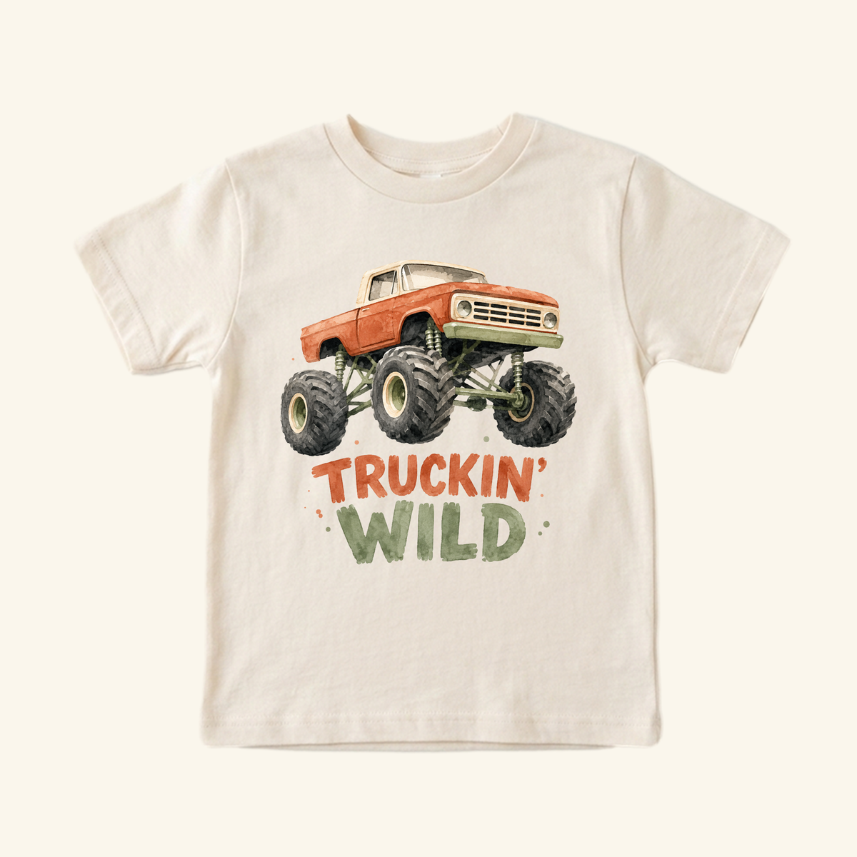 Monster Truck Toddler Shirt – Truckin’ Wild Short-Sleeve Tee in cream, featuring a watercolor monster truck illustration above the text TRUCKIN WILD in red and green letters.