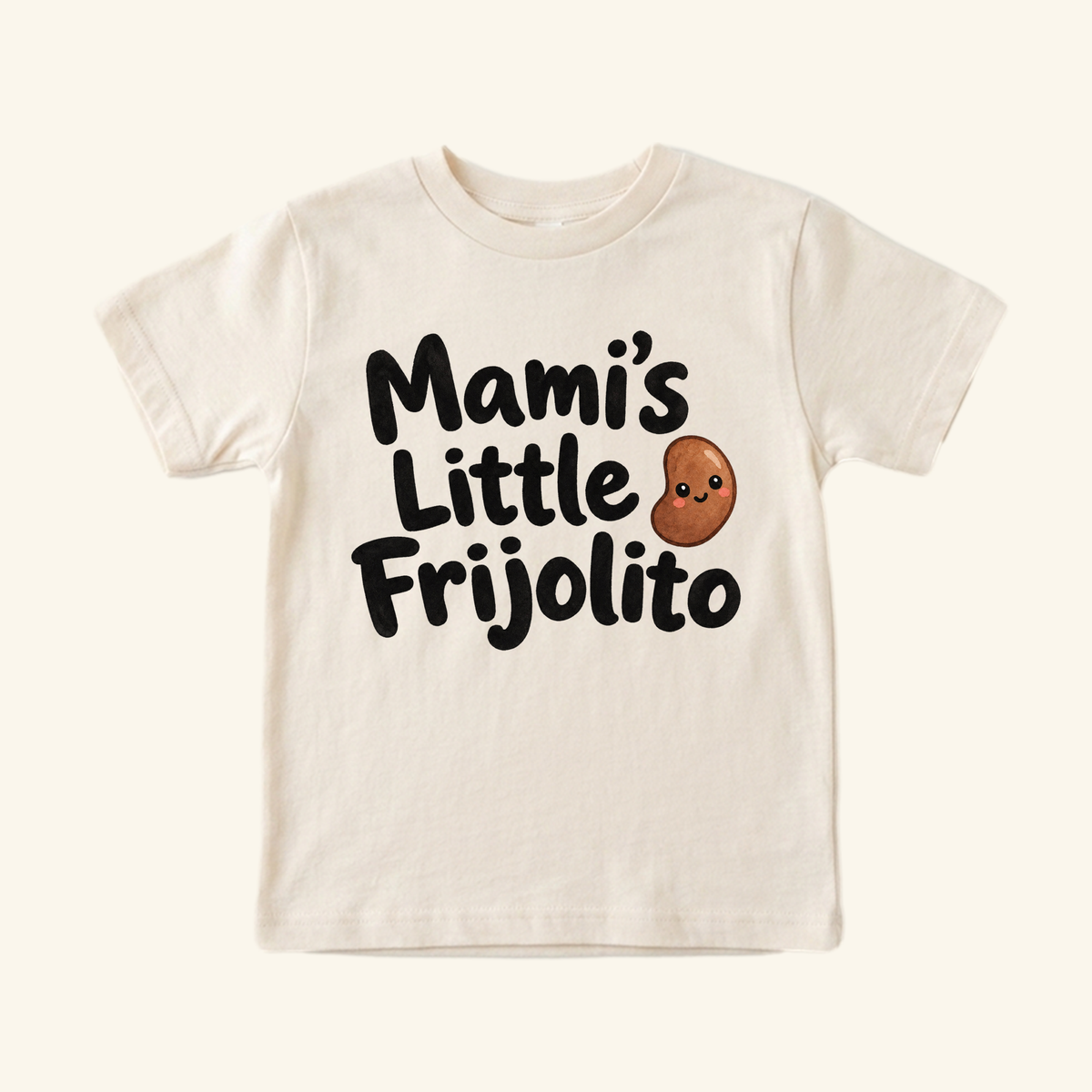 Cream-colored Mami’s Little Frijolito Toddler Shirt featuring a cartoon bean with a face and the text Mami’s Little Frijolito.