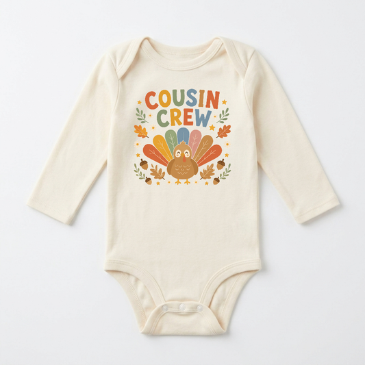 Dress your little one in the Toodleroos Long-Sleeve Thanksgiving Cousin Baby Onesie – a cream-colored bodysuit featuring a cheerful cartoon turkey, vibrant autumn leaves, and playful “Cousin Crew” text on the front. With orange, yellow, green, and blue accents, this adorable outfit is perfect for festive family gatherings!.