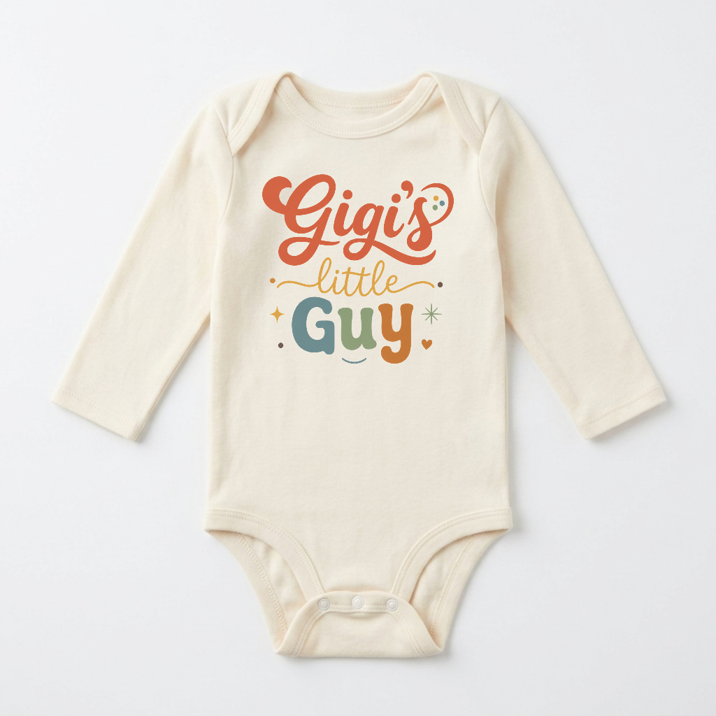 Dress your little one in the Toodleroos Long-Sleeve Gigi Baby Onesie – Gigi’s Little Guy Grandson Bodysuit, a cream-colored outfit featuring “Gigi’s little guy” playfully written in orange, green, and yellow letters with heart and star accents—an adorable gift for any grandson.