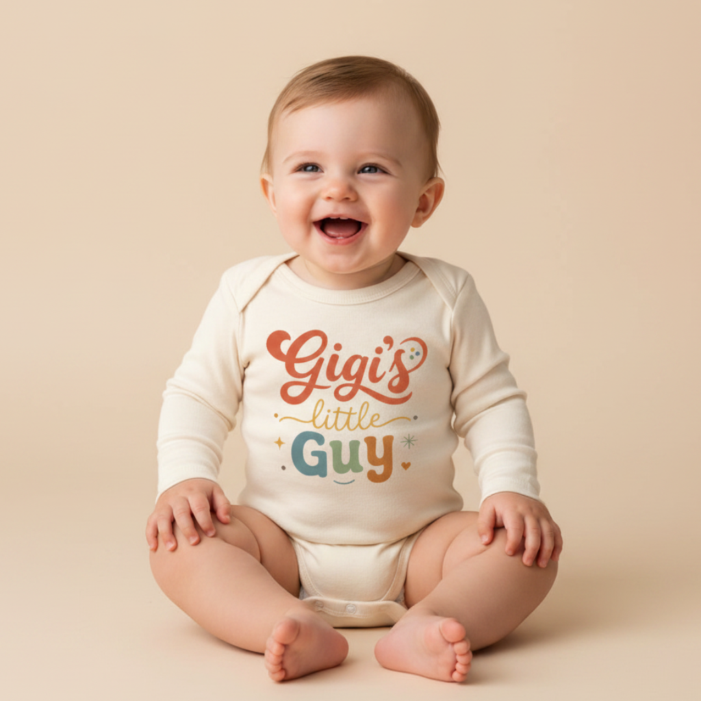 A smiling baby sits on a beige background, wearing the Toodleroos Long-Sleeve Gigi Baby Onesie that reads “Gigi’s Little Guy” in playful orange, yellow, and teal letters—a perfect gift for any grandson.