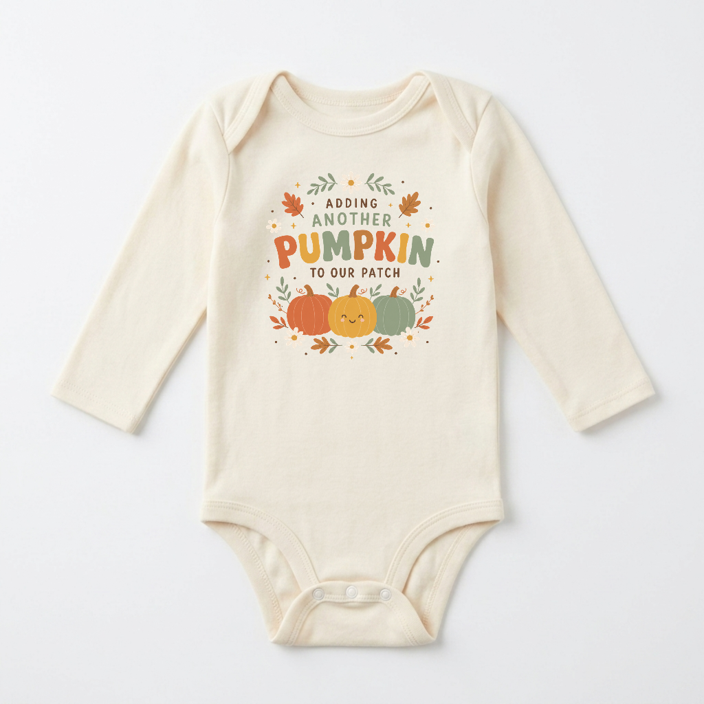Toodleroos Long-Sleeve Fall Pregnancy Announcement Onesie – Adding Another Pumpkin: This cream-colored baby bodysuit features autumn leaves, two pumpkins, and the phrase “Adding another pumpkin to our patch” printed on the front—a charming choice for a pumpkin patch pregnancy announcement or autumn pregnancy reveal.