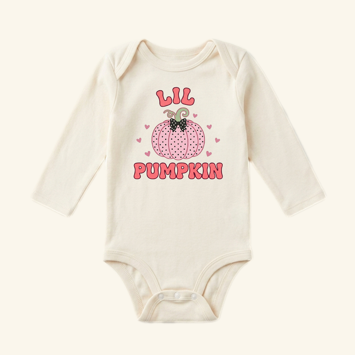 Lil Pumpkin Baby Girl Onesie – Fall Pumpkin Bodysuit featuring a long-sleeved cream bodysuit with a pink polka-dot pumpkin graphic, a bow, and the text LIL PUMPKIN.