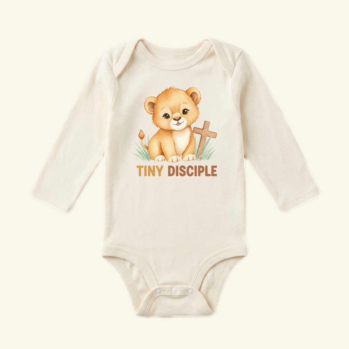 The Christian Baby Onesie – Tiny Disciple Lion Bodysuit by Toodleroos features a cute lion cub, wooden cross, green grass, and TINY DISCIPLE—a perfect Christian baby gift.