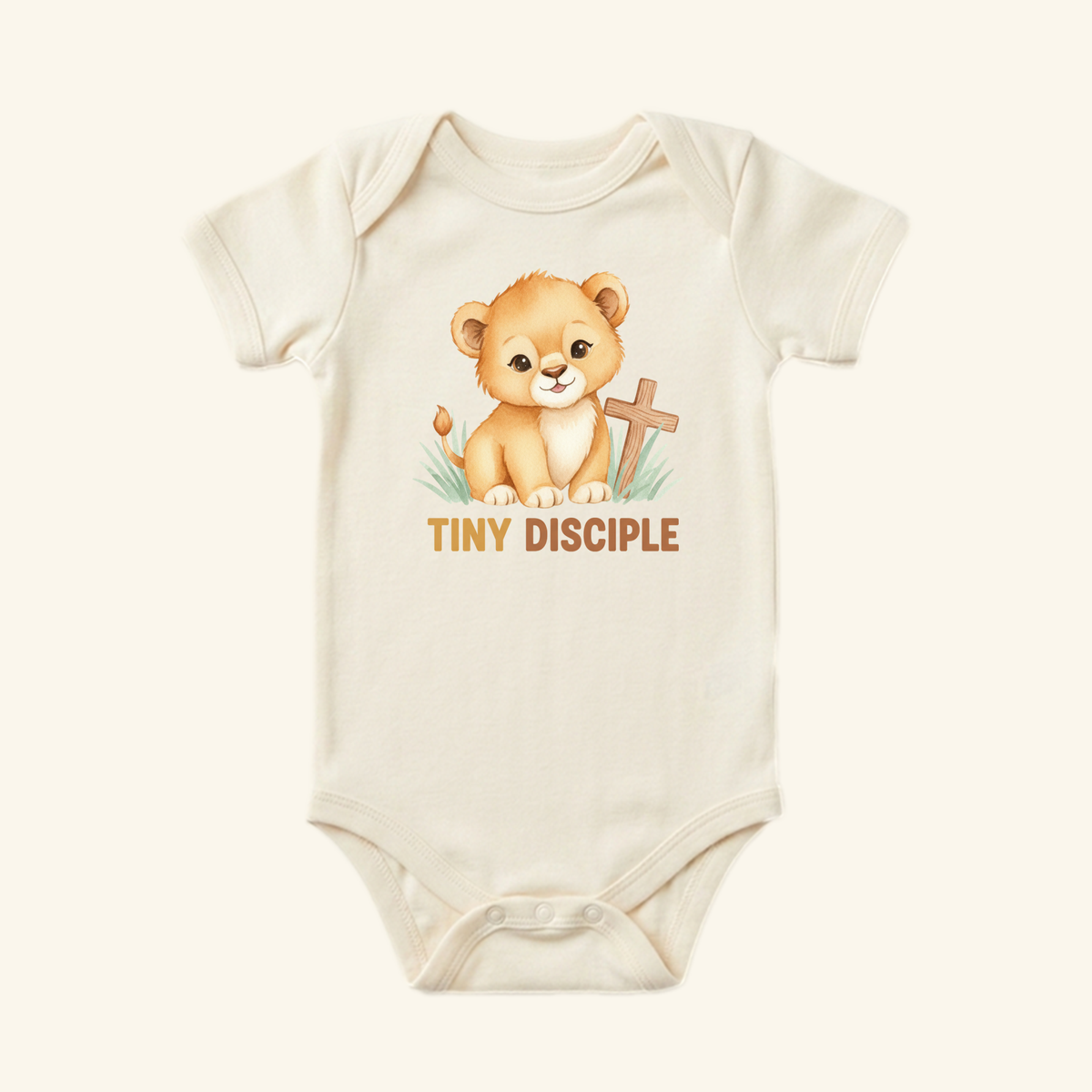 The Toodleroos Christian Baby Onesie – Tiny Disciple Lion Bodysuit features a cream color, adorable lion cub by a cross, and TINY DISCIPLE text—an ideal Christian baby gift.