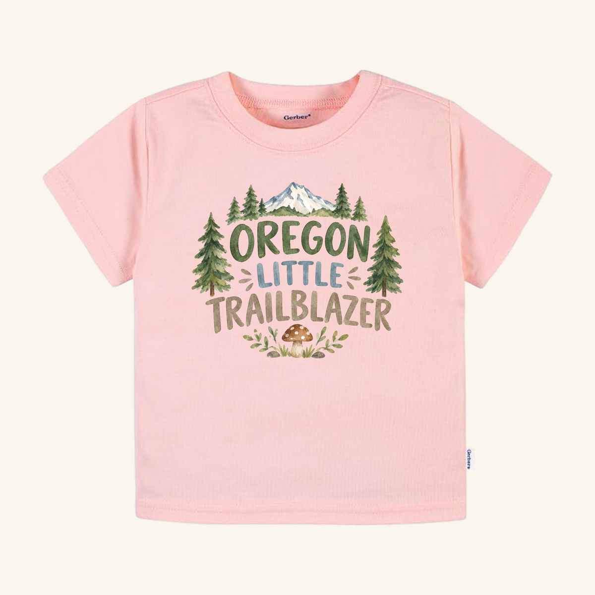 Light pink Toodleroos Oregon Toddler Shirt – Little Trailblazer Mountain Forest Tee featuring a graphic of pine trees and a mushroom with the text Oregon Little Trailblazer.