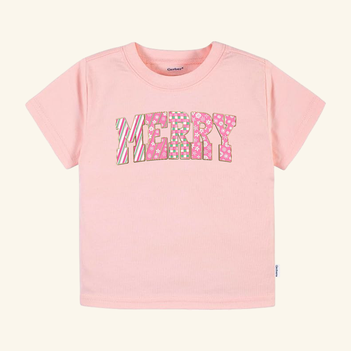 Light pink short-sleeved Merry Toddler Shirt – Pink Candy Cane Christmas Tee with the word MERRY printed on the front in a multi-patterned pink and green candy cane design.
